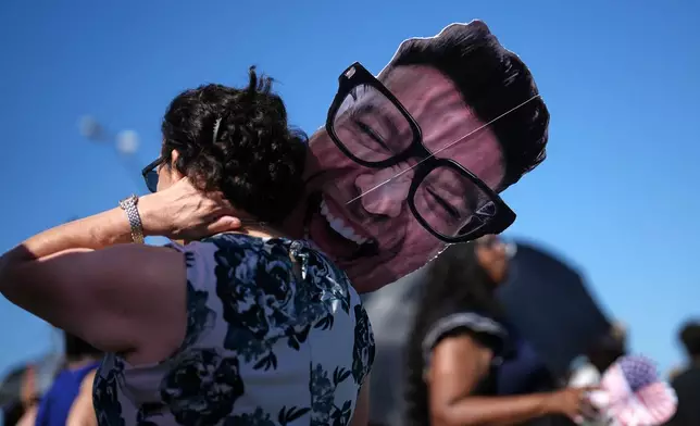 Ofelia Woodruff waits to greet her son, sailor Michael Woodruff, as the USS Abraham Lincoln aircraft carrier returns to Naval Air Station North Island after deployment Thursday, Oct. 8, 2026, in Coronado, Calif. (AP Photo/Gregory Bull)