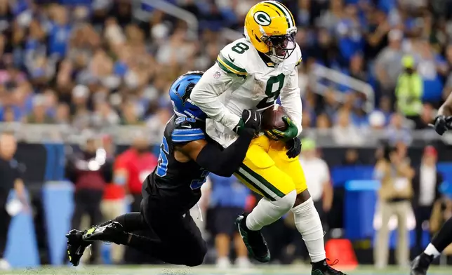 Green Bay Packers running back Josh Jacobs (8) is tackled by Detroit Lions safety Chuck Clark (36) during the first half of an NFL football game, Sunday, Oct. 25, 2026, in Detroit. (AP Photo/Rey Del Rio)