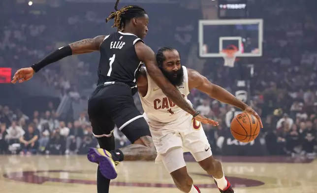 Cleveland Cavaliers guard James Harden, right, drives against Brooklyn Nets guard Keon Ellis, left, in the first half of an NBA basketball game in Cleveland, Saturday, Oct. 24, 2026. (AP Photo/Tim Phillis)