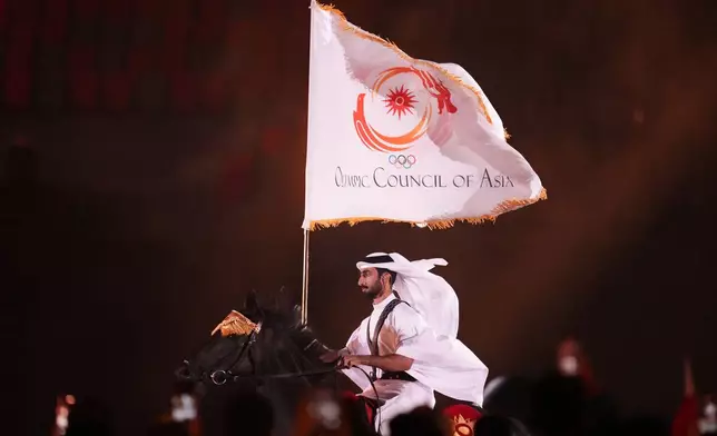 Qatar equestrian athlete Jassim Al Kuwari rides with the Olympic Council of Asia flag during the closing ceremony for the Asian Games in Nagoya, Japan, Sunday, Oct. 4, 2026. (AP Photo/Lee Jin-man)