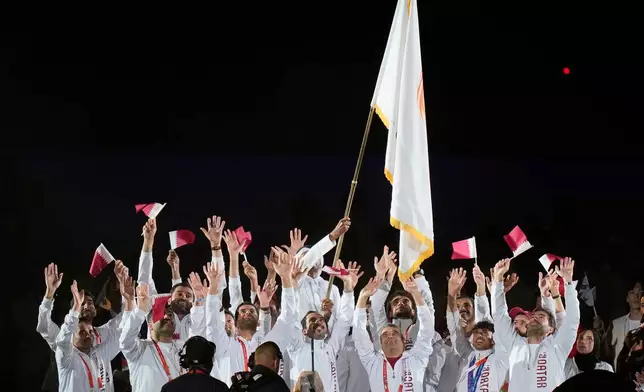 Athletes from Qatar react after receiving the Olympic Council of Asia flag during the closing ceremony for the Asian Games in Nagoya, Japan, Sunday, Oct. 4, 2026. (AP Photo/Eugene Hoshiko)