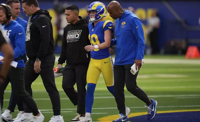 Los Angeles Rams kicker Blake Grupe (19) walks off the field with trainers during the first half of an NFL football game against the Arizona Cardinals in Inglewood, Calif., Sunday, Oct. 18, 2026. (AP Photo/Gregory Bull)