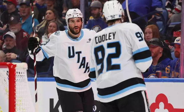 Utah Mammoth center Nick Schmaltz (8) celebrates his goal with center Logan Cooley (92) during the second period of an NHL hockey game against the Buffalo Sabres Saturday, Oct. 10, 2026, in Buffalo, N.Y. (AP Photo/Jeffrey T. Barnes)