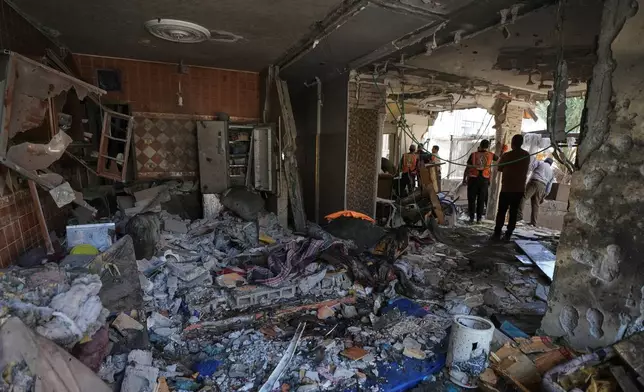 Palestinians inspect the damage to an apartment building struck by an Israeli airstrike in Gaza City Tuesday, Oct. 20, 2026. (AP Photo/Jehad Alshrafi)