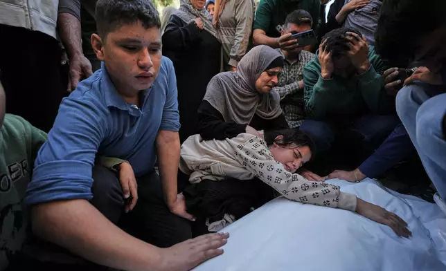 Dima Yassin mourns over the body of her mother, Dina Yassin, during the funeral of her parents, who were killed in an Israeli army strike on an apartment in Gaza City, Tuesday, Oct. 20, 2026. (AP Photo/Jehad Alshrafi)