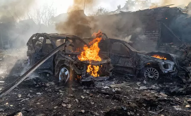 Cars burn after a Russian strike on a residential neighbourhood in Kharkiv, Ukraine, Sunday, Oct. 11, 2026. (AP Photo/Andrii Marienko)