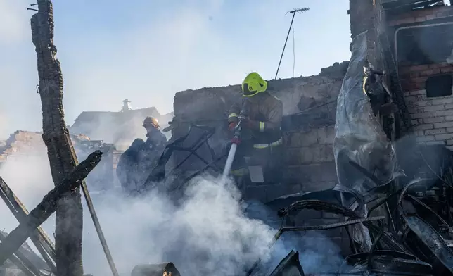 Rescue workers put out a fire of residential houses destroyed in a Russian strike on Kharkiv, Ukraine, Sunday, Oct. 11, 2026. (AP Photo/Andrii Marienko)