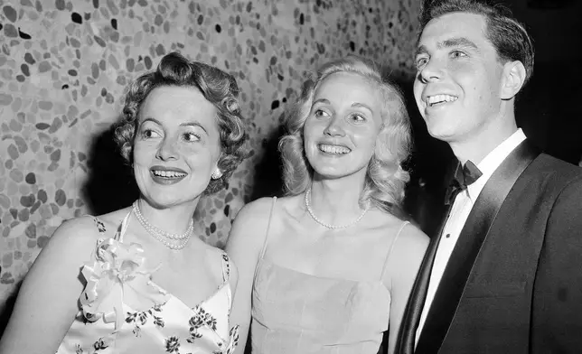 FILE - Attending the annual Motion Picture Costumers ball in Los Angeles, Oct. 25, 1957, from left is Olivia de Havilland, Eva Marie Saint and Jeffrey Hayden. (AP Photo/Harold P. Matosian, File)