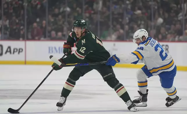 Minnesota Wild left wing Matt Boldy (12) skates with the puck as St. Louis Blues right wing Jonatan Berggren (29) defends during the first period of an NHL hockey game, Thursday, Oct. 15, 2026, in St. Paul, Minn. (AP Photo/Abbie Parr)