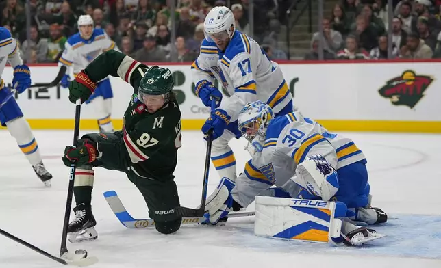 St. Louis Blues goaltender Joel Hofer (30) defends against pressure from Minnesota Wild left wing Kirill Kaprizov (97) during the first period of an NHL hockey game, Thursday, Oct. 15, 2026, in St. Paul, Minn. (AP Photo/Abbie Parr)