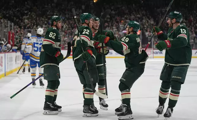 Minnesota Wild right wing Danila Yurov (22) celebrates with teammates after scoring a goal during the first period of an NHL hockey game against the St. Louis Blues, Thursday, Oct. 15, 2026, in St. Paul, Minn. (AP Photo/Abbie Parr)