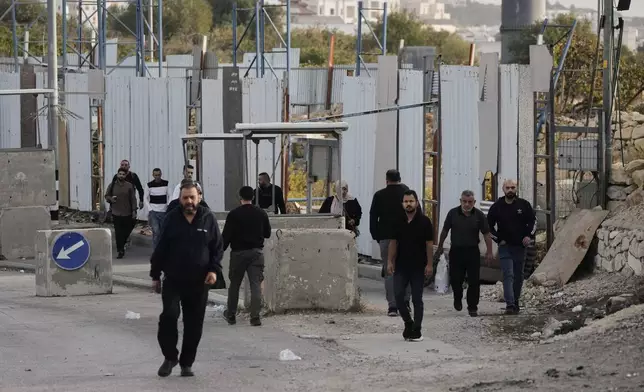 Palestinians cross on foot past a military gate closed to vehicles during an Israeli army operation in Hebron in the occupied West Bank Saturday, Oct. 24, 2026, a day after a Palestinian shooting attack in the area. (AP Photo/Mahmoud Illean)