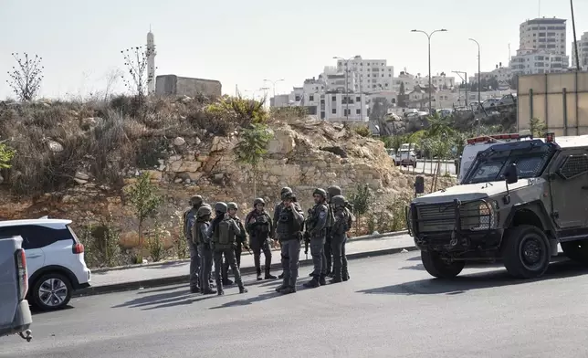 Israeli soldiers gather at the scene of a shooting attack carried out by Palestinian gunmen at a junction near Hebron in the occupied West Bank on Friday, Oct. 23, 2026. (AP Photo/Mahmoud Illean)