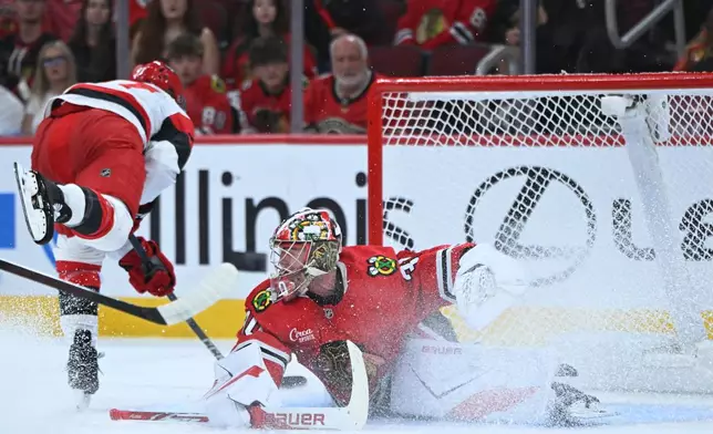 Carolina Hurricanes' Mark Jankowski (77) scores a goal against Chicago Blackhawks goalie Spencer Knight (30) during the first period of an NHL hockey game Saturday, Oct. 10, 2026, in Chicago. (AP Photo/Paul Beaty)
