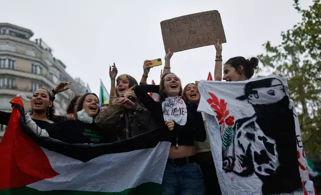 Students chant during a protest against under-resourced schools in Rennes, France, Tuesday, Oct. 13, 2026. The placard reads: "resist to exist." (AP Photo/Jeremias Gonzalez)