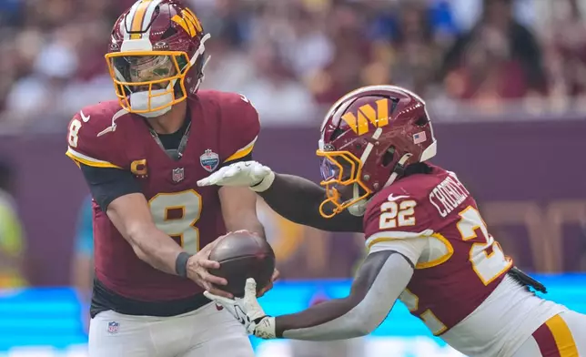 Washington Commanders quarterback Marcus Mariota (8) hands off to Washington Commanders running back Jacory Croskey-Merritt (22) during an NFL football game in London, Sunday, Oct. 4, 2026. (AP Photo/David J. Phillip)