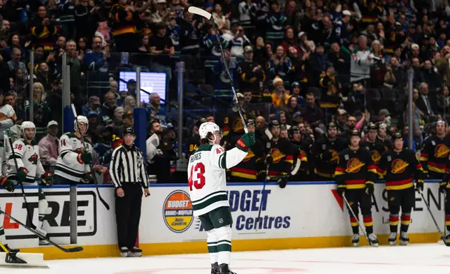 Minnesota Wild's Quinn Hughes (43) waves to the crowd while playing his former team, the Vancouver Canucks, during the first period of an NHL hockey game, in Vancouver, British Columbia, Sunday, Oct. 25, 2026. (Jacob Mallari/The Canadian Press via AP)