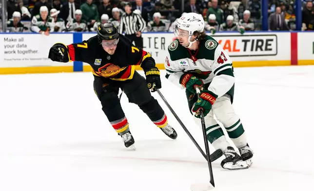 Minnesota Wild's Quinn Hughes (43) skates past Vancouver Canucks' Brendan Gallagher (7) during the second period of an NHL hockey game, in Vancouver, British Columbia, Sunday, Oct. 25, 2026. (Jacob Mallari/The Canadian Press via AP)