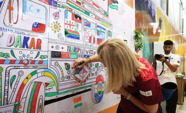 International Olympic Committee President Kirsty Coventry draws on the wall as she visits the Youth Olympic Village in Diamniadio, Senegal, Oct. 29, 2026. (Misper Apawu/Pool Photo via AP)