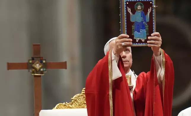Pope Leo XIV holds up the book of the Gospel as he celebrates a mass in St. Peter's Basilica at the Vatican, Thursday, Oct.8, 2026, for the annual opening of the academic year at pontifical universities, joining Rome's 22 pontifical institutions and numerous others worldwide. (AP Photo/Gregorio Borgia)