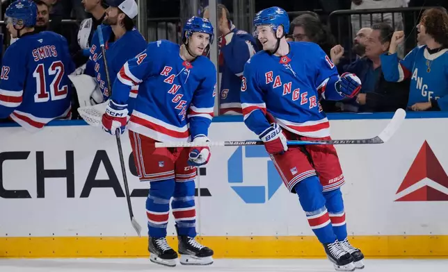 New York Rangers' Alexis Lafrenière, right, celebrates his second goal of the night during the first period of an NHL hockey game against the Tampa Bay Lightning in New York, Tuesday, Oct. 13, 2026. (AP Photo/Seth Wenig)