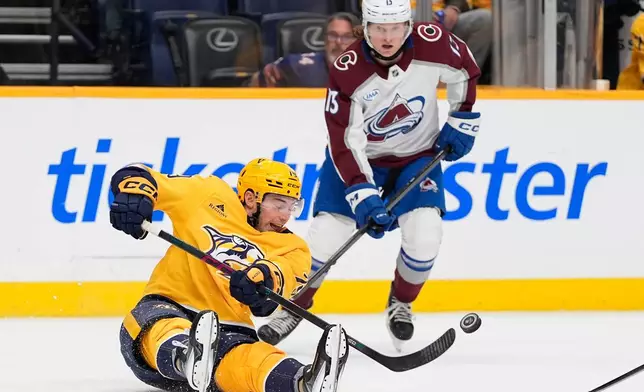 Nashville Predators center Ross Colton (79) passes the puck past Colorado Avalanche right wing T.J. Hughes (13) during the second period of an NHL hockey game Sunday, Oct. 25, 2026, in Nashville, Tenn. (AP Photo/George Walker IV)