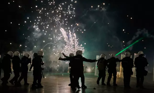 Protesters throw fireworks that explode near riot police during an anti-government protest in Skanderbeg Square, the main square in Tirana, Albania, Tuesday, Oct. 20, 2026. (AP Photo/Boris Grdanoski)
