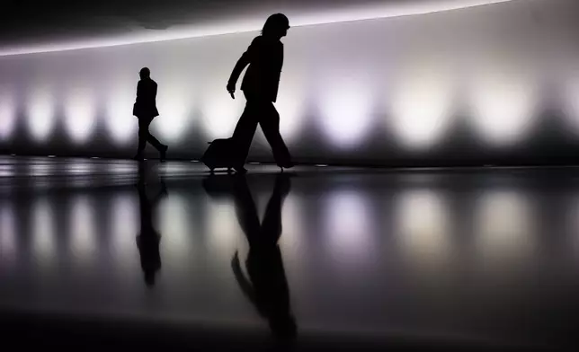 People walk through a tunnel between parliament buildings prior to a session of German parliament Bundestag, in Berlin, Germany, Wednesday, Oct. 14, 2026. (AP Photo/Markus Schreiber)