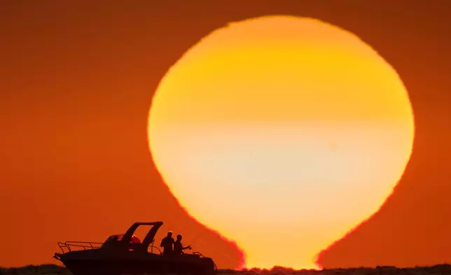 Fishermen are silhouetted aboard a boat as the sun sets over the Mediterranean Sea in Beirut, Lebanon, Thursday, Oct. 8, 2026. (AP Photo/Hassan Ammar)