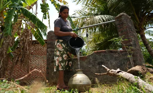 Hemapala Mallika fills a pot with water she drew from a depleted well due to drought in Medirigiriya, Sri Lanka, Sunday, Sept. 13, 2026. (AP Photo/Eranga Jayawardena)