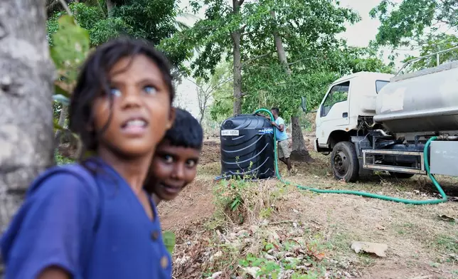 Local government workers pump water from a truck into a temporary tank during a drought in Medirigiriya, Sri Lanka, Sunday, Sept. 13, 2026. (AP Photo/Eranga Jayawardena)