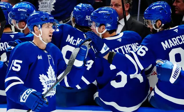 Toronto Maple Leafs' Colton Sissons (15) celebrates his goal against the New York Islanders with teammates during the first period of an NHL hockey game in Toronto, Wednesday, Sept. 30, 2026. (Frank Gunn/The Canadian Press via AP)