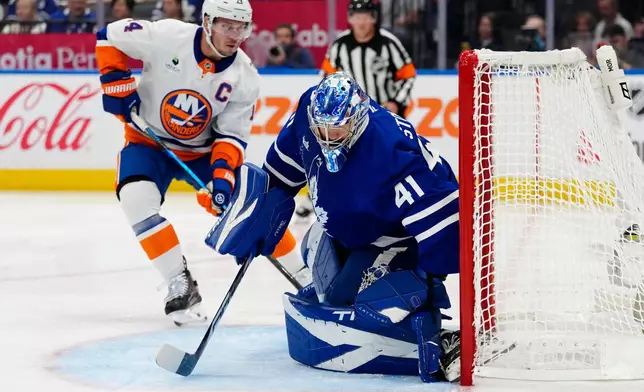 Toronto Maple Leafs goaltender Anthony Stolarz (41) makes a save as New York Islanders' Bo Horvat (14) looks for the rebound during the first period of an NHL hockey game in Toronto, Wednesday, Sept. 30, 2026. (Frank Gunn/The Canadian Press via AP)