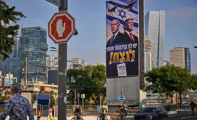 People walk past a Likud Party campaign billboard featuring U.S. President Donald Trump and Israeli Prime Minister Benjamin Netanyahu, with a Hebrew message reading, "We have one opportunity to win," in Tel Aviv, Israel, Monday, Oct. 26, 2026. (AP Photo/Oded Balilty)