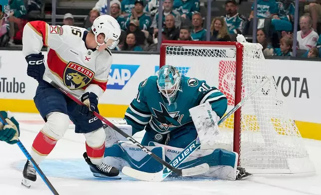 San Jose Sharks goaltender Yaroslav Askarov (30) blocks a shot against Florida Panthers center Anton Lundell (15) during the second period of an NHL hockey game in San Jose, Calif., Thursday, Oct. 1, 2026. (AP Photo/Tony Avelar)