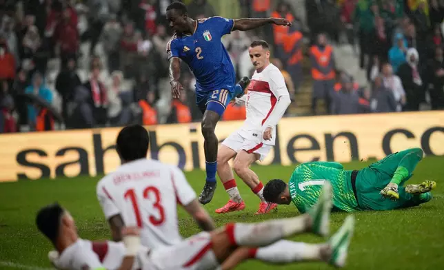 Turkey's goalkeeper Altay Bayindir, right, makes a save as Italy's Michael Kayode, centre, challenges during the UEFA Nations League soccer match between Turkey and Italy in Bursa, Turkey, Monday, Sept. 28, 2026. (AP Photo/Khalil Hamra)