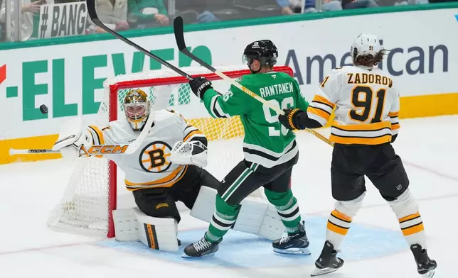 Dallas Stars right wing Mikko Rantanen, center, attacks against Boston Bruins goaltender Jeremy Swayman, left, and defenseman Nikita Zadorov during the third period of an NHL hockey game Tuesday, Oct. 20, 2026, in Dallas. (AP Photo/Julio Cortez)