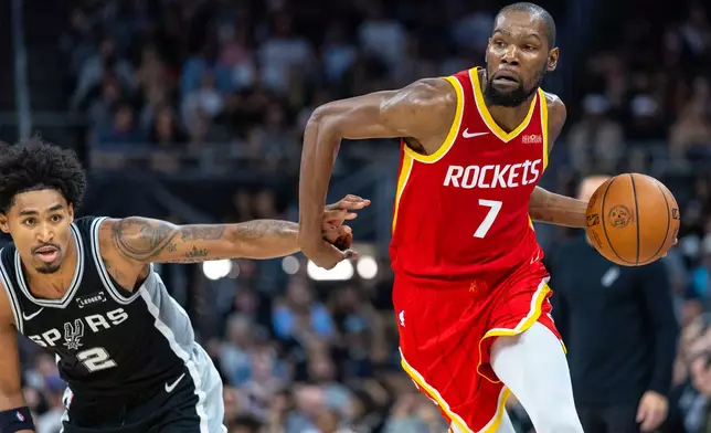 Houston Rockets forward Kevin Durant (7) drives past San Antonio Spurs guard Dylan Harper (2) during the first half of an NBA basketball game in Austin, Texas, Friday, Oct. 23, 2026. (AP Photo/Stephen Spillman)