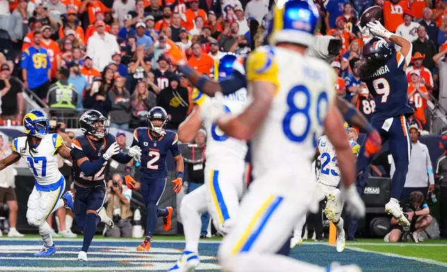 Denver Broncos safety Talanoa Hufanga (9) makes an interception on a pass from Los Angeles Rams quarterback Matthew Stafford on the final play of an NFL football game Sunday, Sept. 27, 2026, in Denver. (AP Photo/Jack Dempsey)