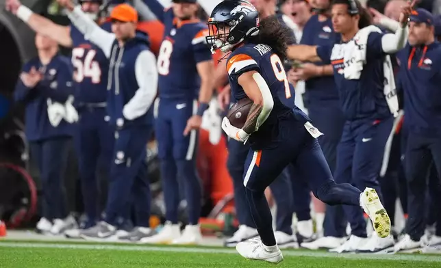 Denver Broncos safety Talanoa Hufanga returns an interception for a touchdown on a pass by Los Angeles Rams quarterback Matthew Stafford during the second half of an NFL football game Sunday, Sept. 27, 2026, in Denver. (AP Photo/David Zalubowski)