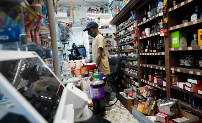 Merchant Frank Levy works behind the counter at a gas station food mart in the Scotlandville section of Baton Rouge, La., Monday, Sept. 14, 2026. (AP Photo/Gerald Herbert)
