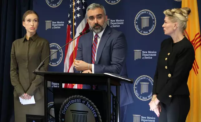 New Mexico Attorney General Raúl Torrez stands with Julia Molchanova, left, and Anouska De Georgiou, right, as he answers questions about a lawsuit against the co-executors of Jeffrey Epstein's estate during a news conference in Albuquerque, N.M., on Wednesday, Oct. 21, 2026. (AP Photo/Susan Montoya Bryan)