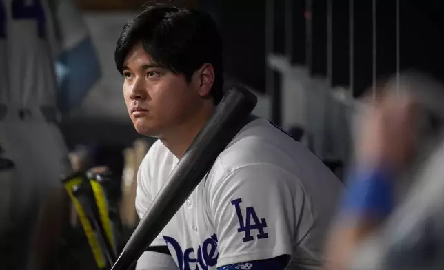Los Angeles Dodgers designated hitter Shohei Ohtani watches from the dugout during the ninth inning of Game 4 of baseball's National League Championship Series between the Milwaukee Brewers and the Los Angeles Dodgers, Thursday, Oct. 15, 2026, in Los Angeles. (AP Photo/Gregory Bull)
