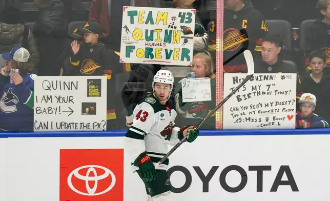 Fans watch as Minnesota Wilds' Quinn Hughes (43) participates in the pre-game skate before an NHL hockey game against his former team, the Vancouver Canucks, in Vancouver, British Columbia, Sunday, Oct. 25, 2026. (Jacob Mallari/The Canadian Press via AP)