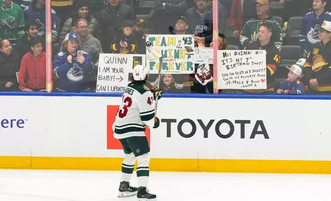Minnesota Wilds' Quinn Hughes (43) sends a puck into the crowd in the pre-game skate before an NHL hockey game against his former team, the Vancouver Canucks, in Vancouver, British Columbia, Sunday, Oct. 25, 2026. (Jacob Mallari/The Canadian Press via AP)