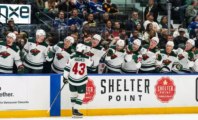 Minnesota Wild's Quinn Hughes (43) celebrates with his teammates after scoring a goal during the second period of an NHL hockey game, in Vancouver, British Columbia, Sunday, Oct. 25, 2026. (Jacob Mallari/The Canadian Press via AP)