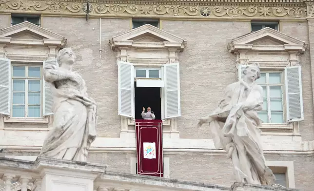 Pope Leo XIV appears at the window of his study in the Apostolic Palace overlooking St. Peter's Square at the Vatican for the traditional noon blessing after praying the Angelus, Sunday, Oct. 18, 2026, a day after he returned from the hospital, where he had lung cancer removed on Tuesday. (AP Photo/Gregorio Borgia)