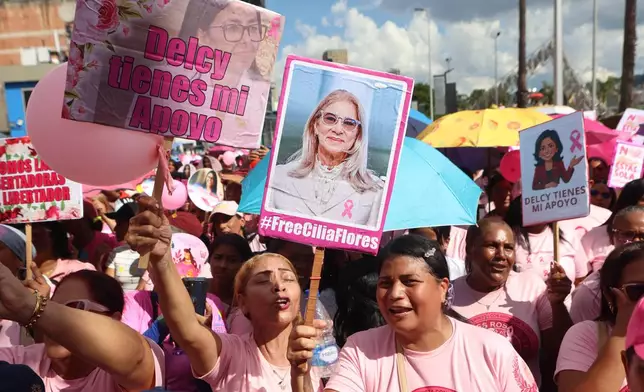 A woman holds a sign of former first lady Cilia Flores during a government-organized march to raise breast cancer awareness during Pink Month in Caracas, Venezuela, Thursday, Oct. 22, 2026. (AP Photo/Pedro Mattey)