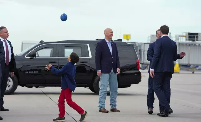 Vice President JD Vance is greeted by Sen. Pete Ricketts, R-Neb., and Nebraska Gov. Jim Pillen, as his son Vivek plays with a football, upon his arrival to North Platte Regional Airport in North Platte, Neb., Thursday, Oct. 22, 2026, en route to a campaign rally. (AP Photo/Jacquelyn Martin, Pool)