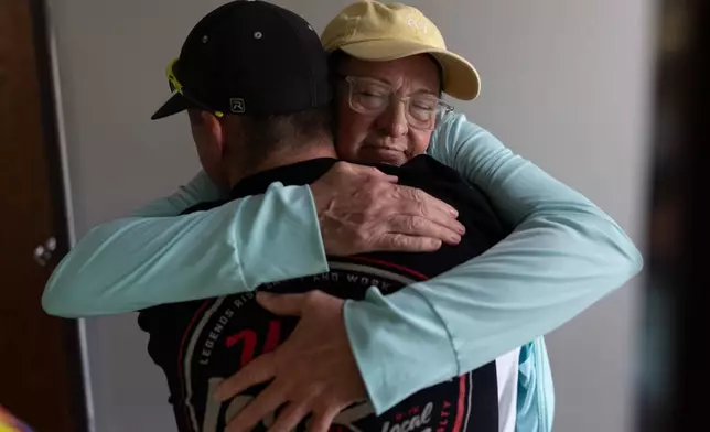 UAW Local 402 members, Brad Cloud, left, and Marianne Donnelly, right, embrace at the union hall, in Springfield, Ohio, Wednesday, Sept. 30, 2026, old Navistar last day at its Springfield plant. (AP Photo/Carolyn Kaster)